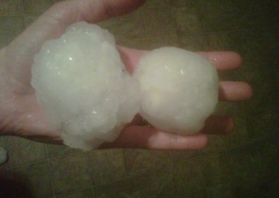 Hand Holding Two Huge Hailstones
