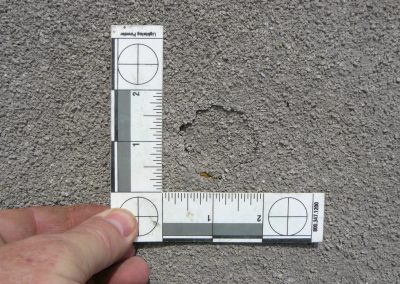 Inspector Measuring Round Crack In SPF Roofing